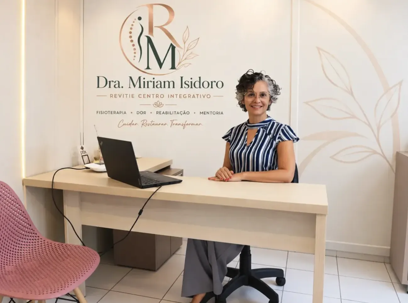 Dra. Miriam Isidoro sentada à mesa em seu consultório no Revitie Centro Integrativo
